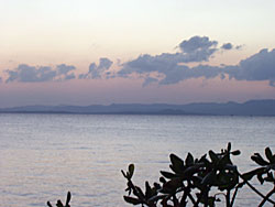 夕暮れ時の赤い空の手前に見える小浜島のシルエット